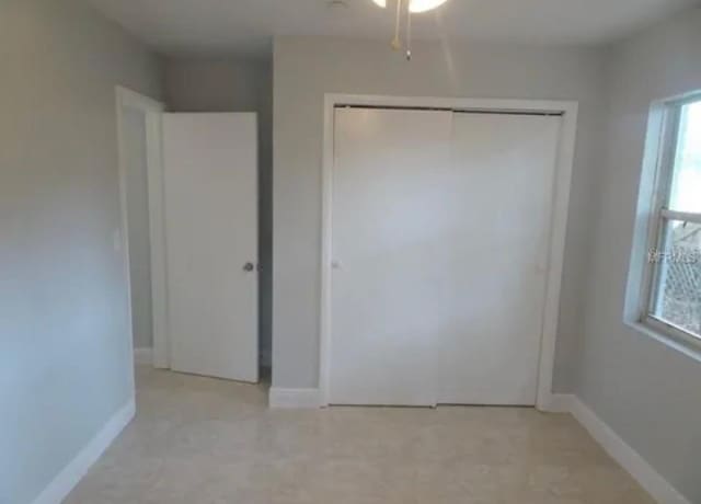 unfurnished bedroom featuring baseboards and a closet