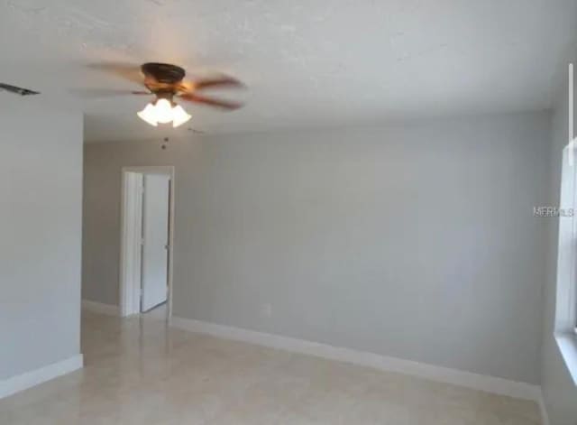 unfurnished room featuring visible vents, baseboards, and a ceiling fan