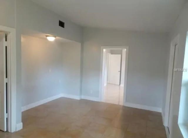 empty room with baseboards and visible vents