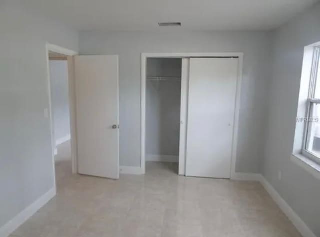 unfurnished bedroom featuring a closet and baseboards