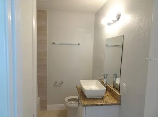 bathroom featuring vanity, toilet, and baseboards