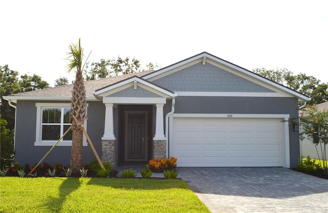 5206 125th Ave E, Parrish, FL 34219 - craftsman inspired home with decorative driveway, a front yard, stucco siding, and an attached garage