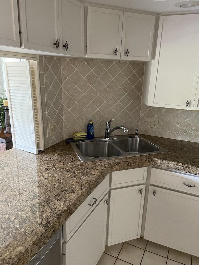 kitchen featuring light tile patterned floors, decorative backsplash, white cabinets, and a sink