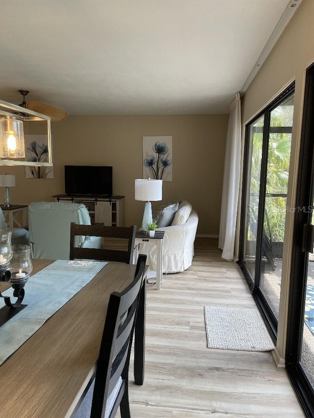 dining space featuring light wood-type flooring and baseboards