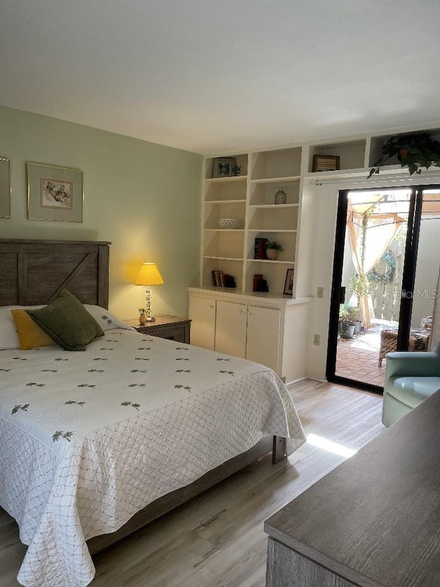 bedroom with access to outside and light wood-style flooring