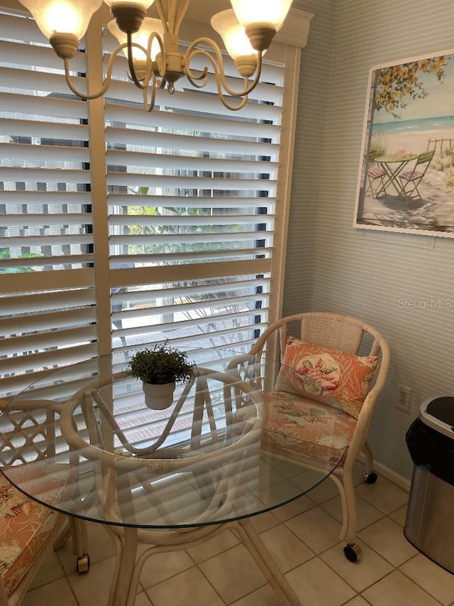 tiled dining room with a chandelier, wallpapered walls, and baseboards