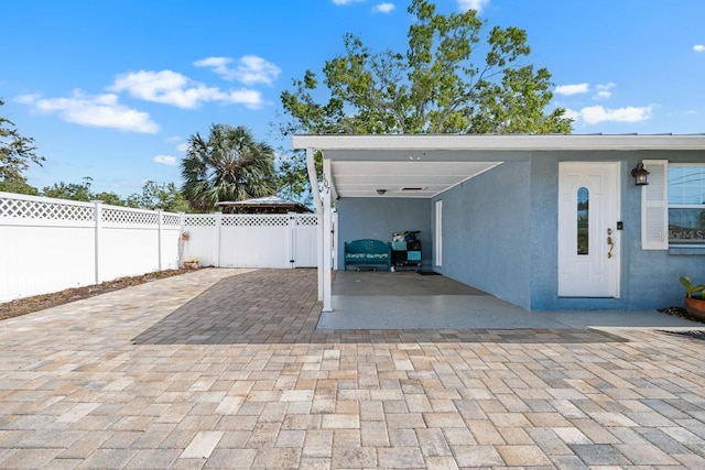 exterior space featuring an attached carport, fence, and driveway