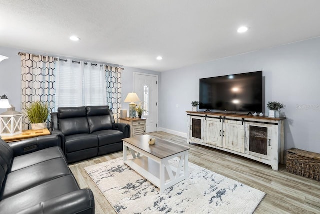 living room featuring recessed lighting, baseboards, and wood finished floors