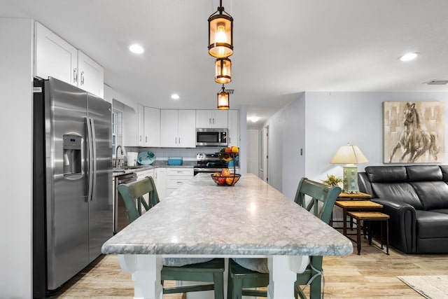 kitchen featuring white cabinetry, light wood-style flooring, visible vents, and stainless steel appliances