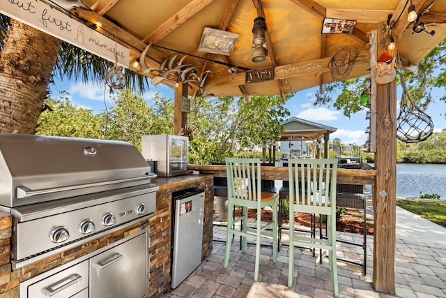 view of patio / terrace with a gazebo, grilling area, a water view, and area for grilling