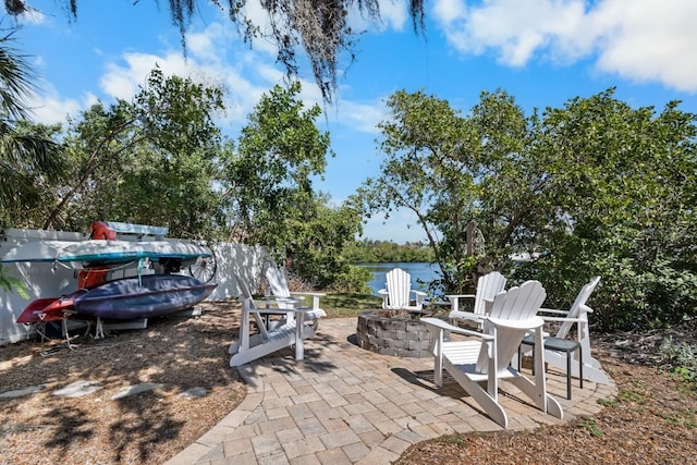 view of patio with an outdoor fire pit and a water view