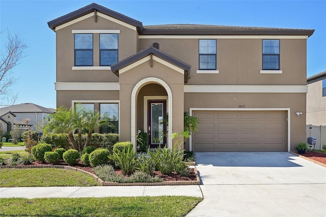 traditional home featuring stucco siding, a garage, and concrete driveway