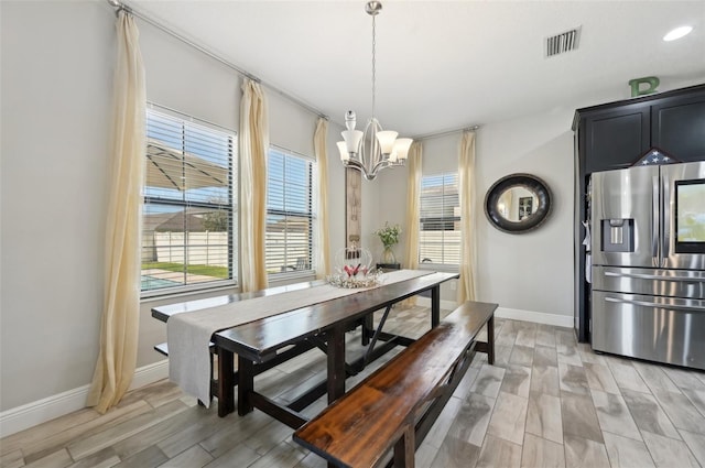 dining room with a chandelier, visible vents, plenty of natural light, and baseboards