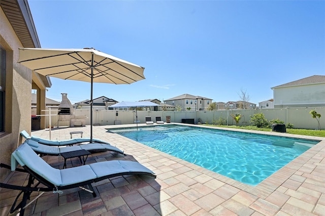 view of pool featuring a fenced backyard, a residential view, a fenced in pool, and a patio