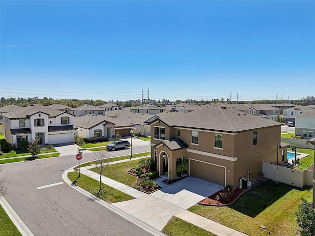 townhome / multi-family property featuring a front lawn, a residential view, concrete driveway, stucco siding, and a garage