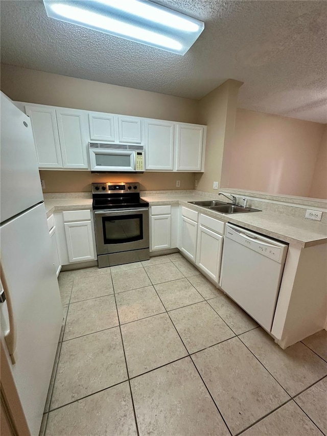 kitchen with light tile patterned flooring, white appliances, light countertops, and a peninsula