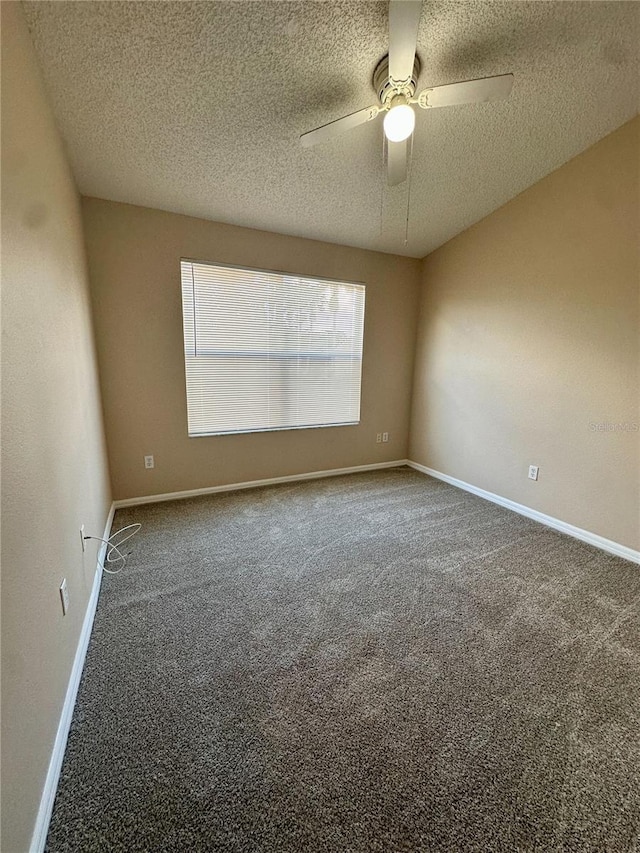 carpeted spare room featuring a textured ceiling, baseboards, and ceiling fan