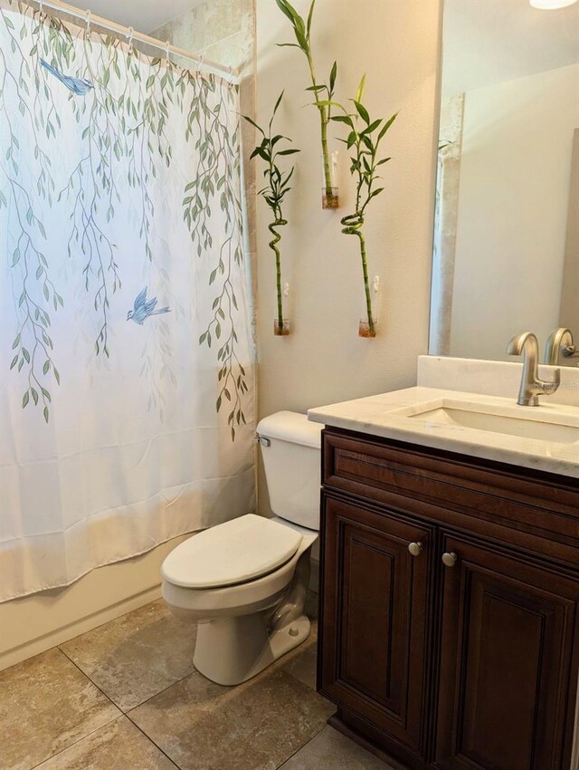 full bath featuring tile patterned floors, toilet, vanity, and shower / bathtub combination with curtain