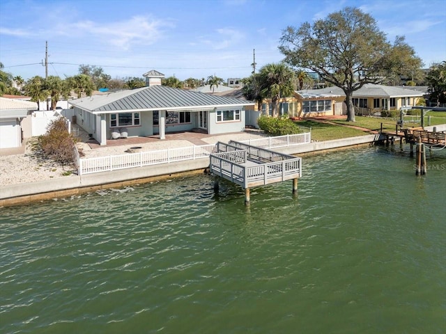 dock area with a patio area, a fenced backyard, and a water view