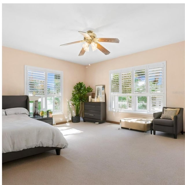 carpeted bedroom featuring baseboards and ceiling fan