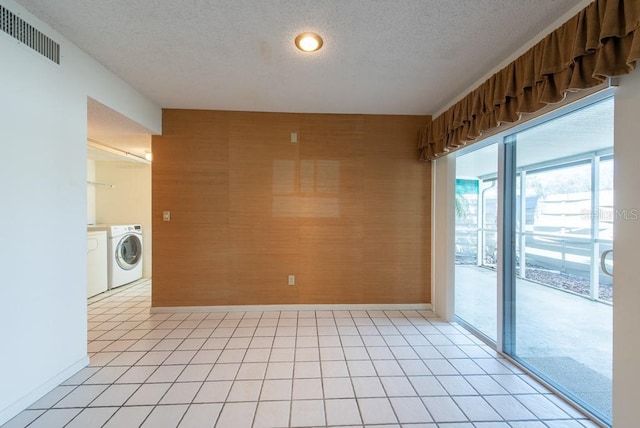 empty room featuring baseboards, visible vents, independent washer and dryer, and a textured ceiling