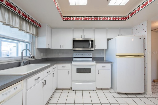 kitchen featuring a sink, decorative backsplash, white appliances, and white cabinetry