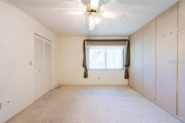 unfurnished bedroom featuring a closet, a textured ceiling, a ceiling fan, and carpet