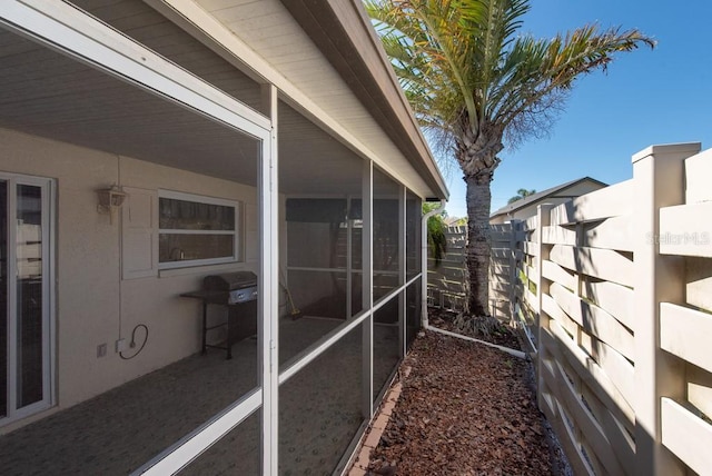 view of side of home with fence and a sunroom