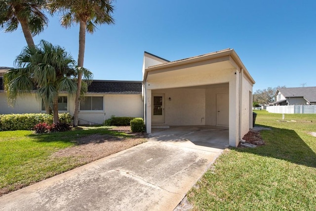 single story home with stucco siding, concrete driveway, a front lawn, and an attached carport