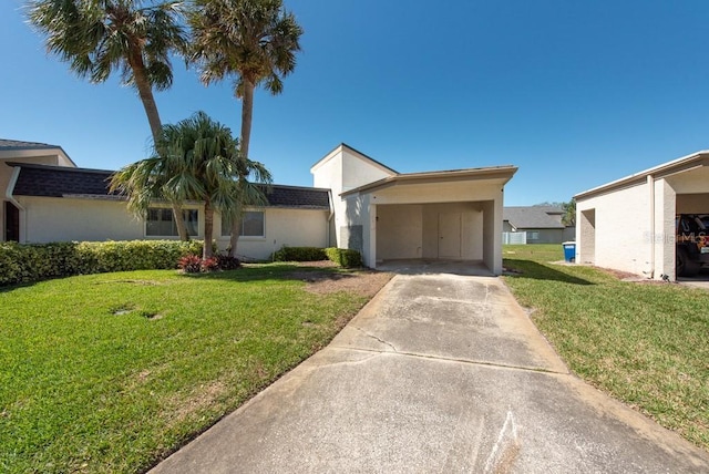 view of front of house featuring stucco siding, driveway, a front lawn, and an attached carport