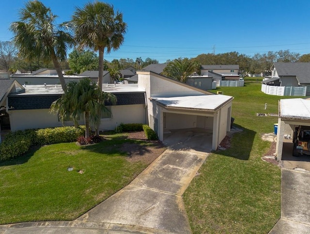 view of front of home featuring a carport, stucco siding, concrete driveway, and a front lawn