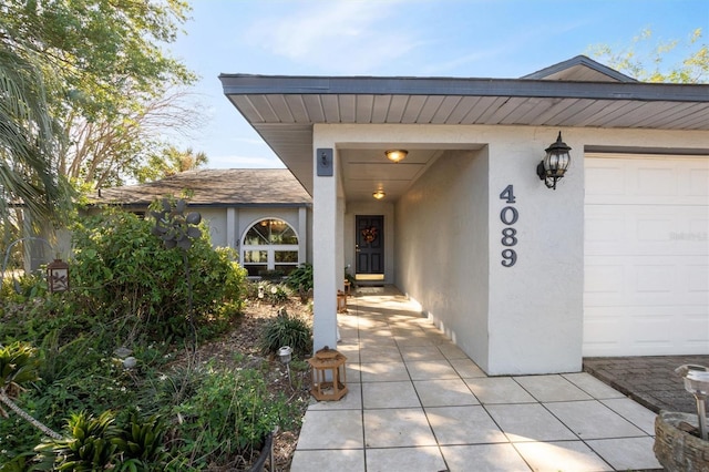 entrance to property featuring stucco siding and a garage