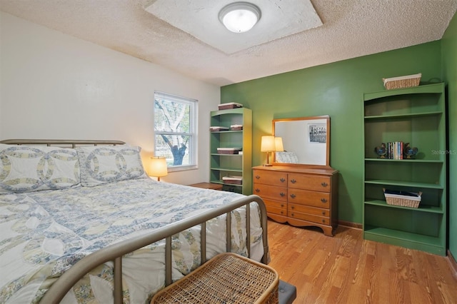 bedroom featuring a textured ceiling and wood finished floors