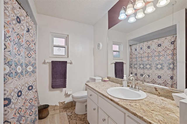 full bath with curtained shower, toilet, vanity, and a textured ceiling