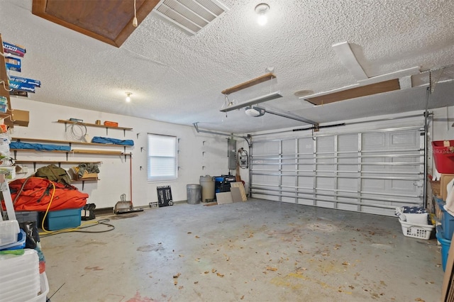 garage with electric panel, visible vents, and a garage door opener