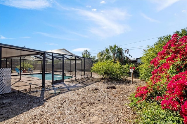 view of yard with a patio area, glass enclosure, and an outdoor pool