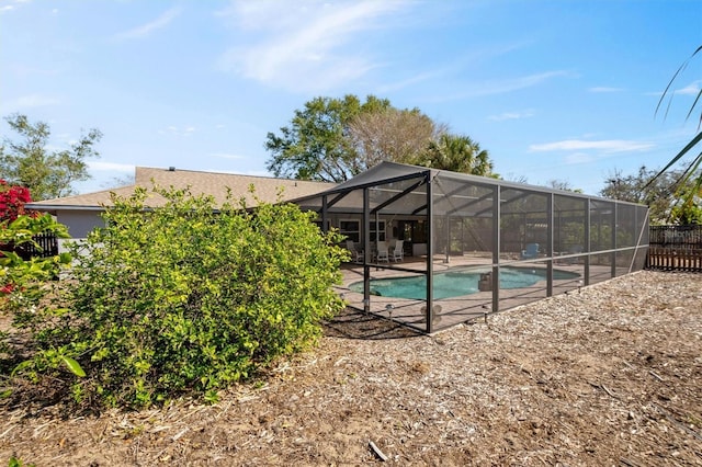 pool with a lanai, a patio area, and fence