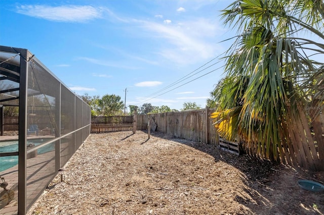 view of yard with a lanai, a fenced backyard, and a fenced in pool