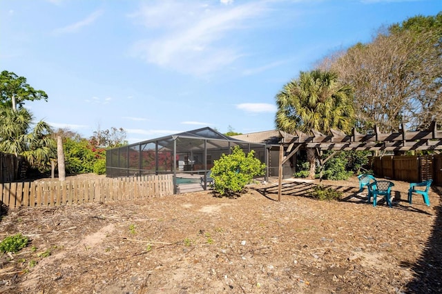 view of yard with a lanai, fence, and a fenced in pool