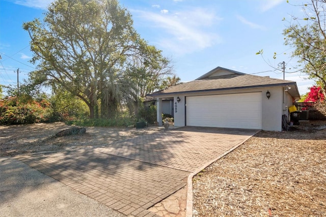 exterior space with decorative driveway, a garage, and stucco siding