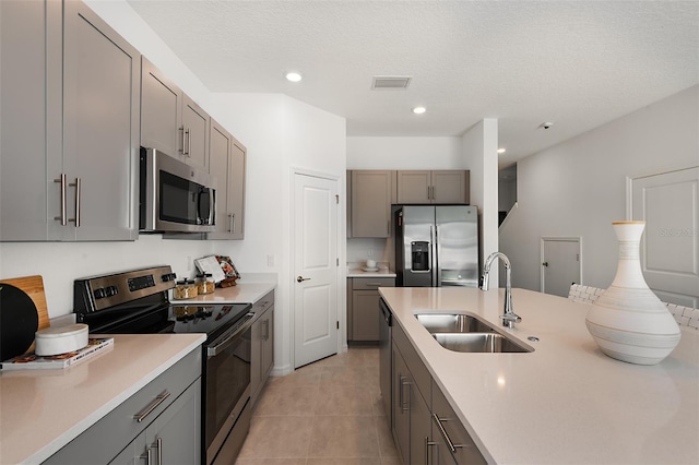 kitchen with a sink, visible vents, gray cabinets, and stainless steel appliances