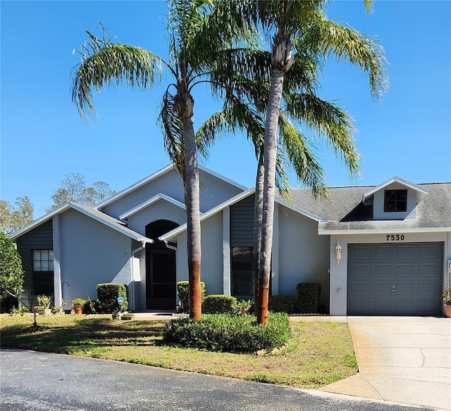 mid-century inspired home featuring stucco siding, an attached garage, and concrete driveway