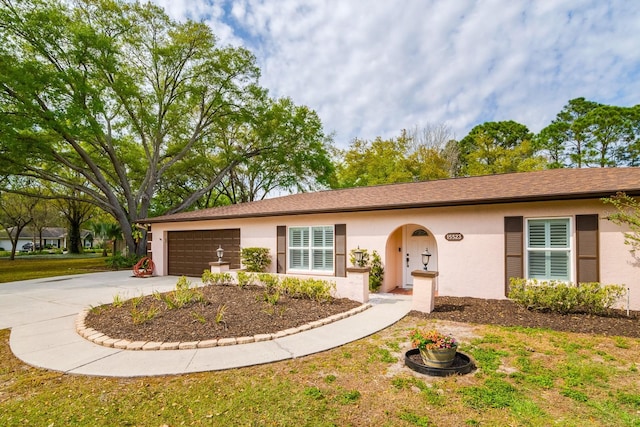 single story home with stucco siding, driveway, and a garage