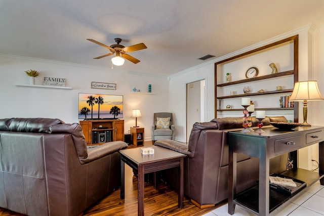 living area featuring crown molding, wood finished floors, a ceiling fan, and visible vents