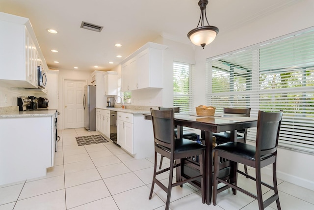 dining space featuring light tile patterned floors, baseboards, visible vents, recessed lighting, and ornamental molding