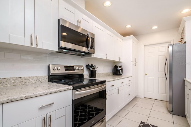 kitchen featuring backsplash, recessed lighting, appliances with stainless steel finishes, white cabinets, and light tile patterned floors