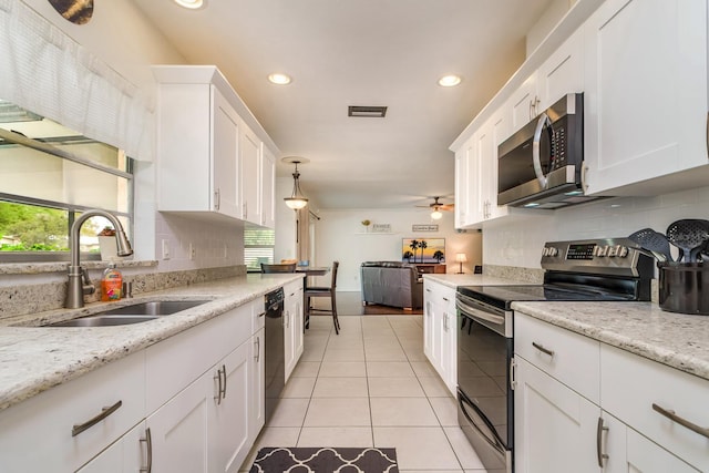 kitchen featuring visible vents, light tile patterned flooring, a sink, white cabinets, and appliances with stainless steel finishes