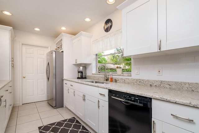 kitchen with black dishwasher, recessed lighting, freestanding refrigerator, white cabinetry, and a sink