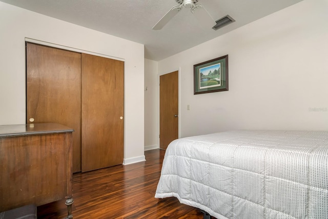 bedroom with visible vents, baseboards, ceiling fan, wood finished floors, and a closet