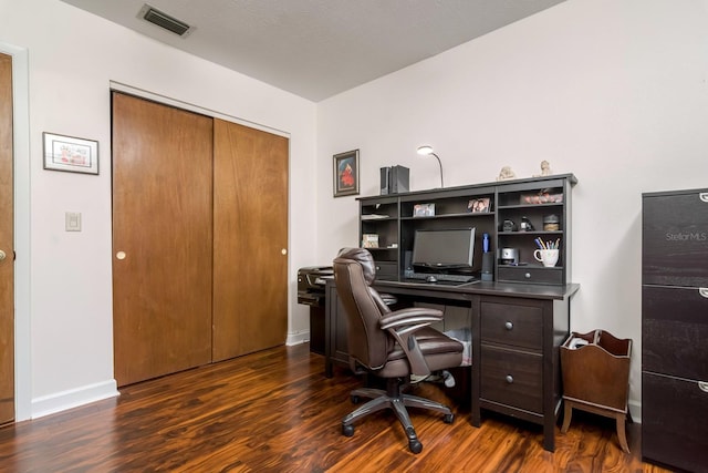 home office featuring dark wood-type flooring, baseboards, and visible vents